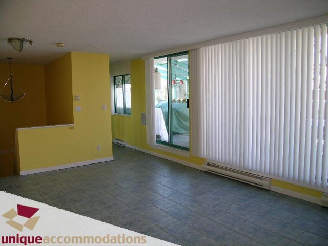 Spacious living room with yellow walls, large windows, and tiled floors. - 703 - 1132 Haro Street, Vancouver Downtown
