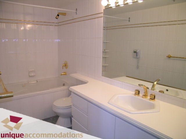 Furnished bathroom with white countertop and gold fixtures. - 703 - 1132 Haro Street, Vancouver Downtown