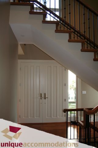 Foyer with white door, hardwood floors, and staircase leading to upper level. - 2550 Marr Creek Ct, West Vancouver