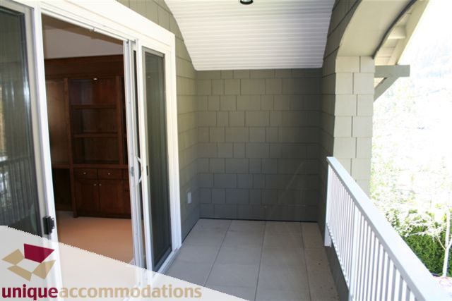 Bright balcony with sliding glass doors and tiled walls, offering a serene outdoor space. - 2550 Marr Creek Ct, West Vancouver