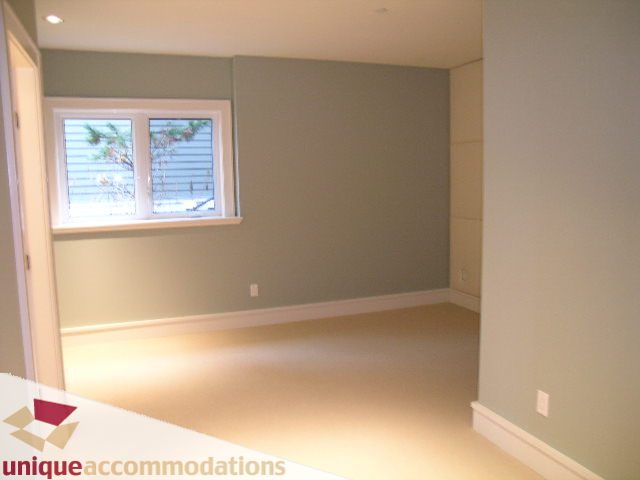 Den with built-in bench seating and a window view of trees. - 2550 Marr Creek Ct, West Vancouver