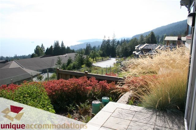 Bright living room with mountain view and vibrant garden. - 2550 Marr Creek Ct, West Vancouver