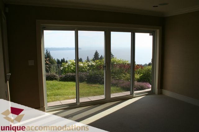 Spacious living room with large windows offering a stunning ocean view. - 2550 Marr Creek Ct, West Vancouver