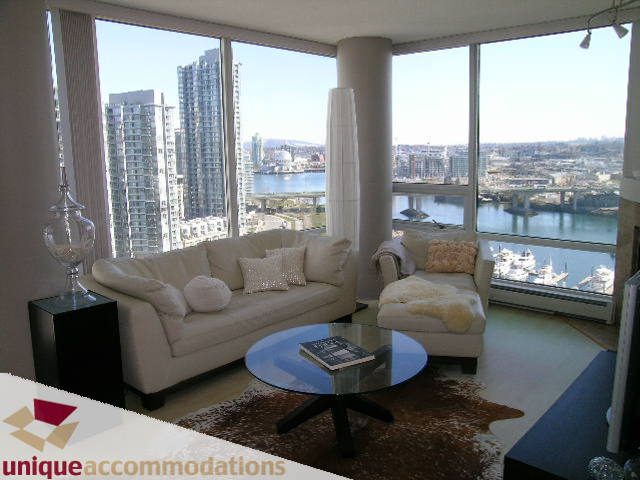 Bright living room with city view, modern furniture, and large windows. - 2003 - 1201 Marinaside Crescent, Vancouver Downtown