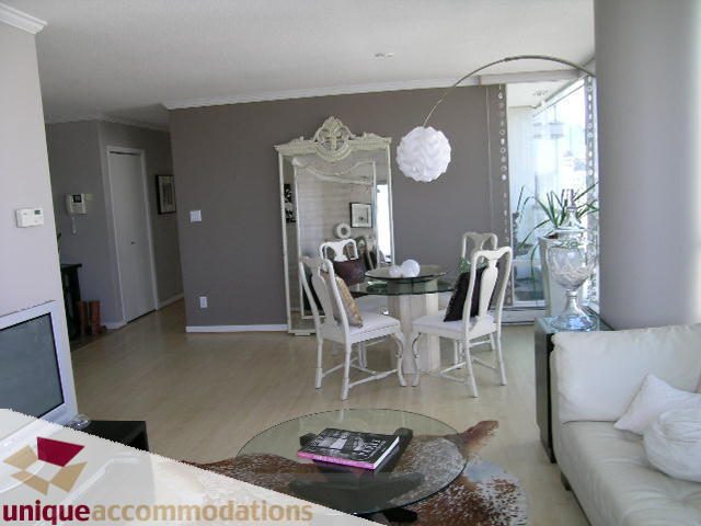 Furnished living room with white furniture, glass coffee table, and large mirror. - 2003 - 1201 Marinaside Crescent, Vancouver Downtown