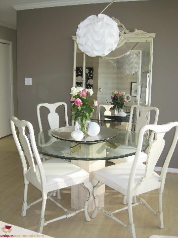 Furnished dining area with white chairs and glass table, modern decor, neutral walls. - 2003 - 1201 Marinaside Crescent, Vancouver Downtown