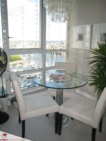 Furnished dining area with glass table, white chairs, and city view. - 2003 - 1201 Marinaside Crescent, Vancouver Downtown