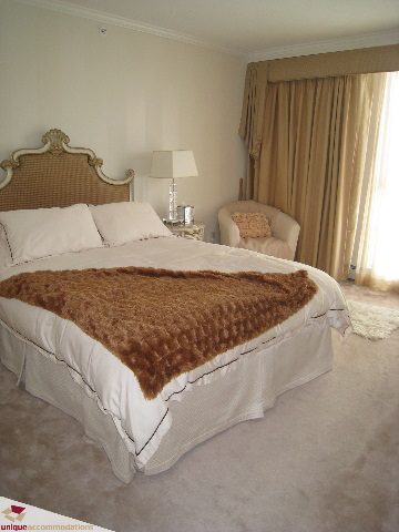 Furnished 2-bedroom + den with plush carpet, large windows, and a cozy bed setup. - 2003 - 1201 Marinaside Crescent, Vancouver Downtown