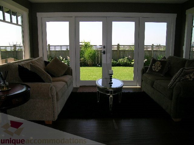 Bright living room with large windows, hardwood floors, and a view of the garden. - 4221 Rockridge Crescent, West Vancouver