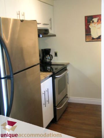 Bright kitchen with stainless steel appliances, granite countertops, and hardwood floors. - 2005 - 1238 Melville, Vancouver Downtown