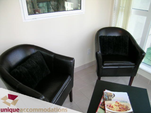 Furnished living room with black leather chairs and a coffee table. - 2005 - 1238 Melville, Vancouver Downtown