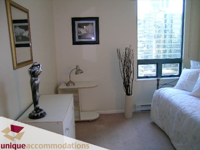 Bright bedroom with city view, modern decor, and white bedding. - 2005 - 1238 Melville, Vancouver Downtown