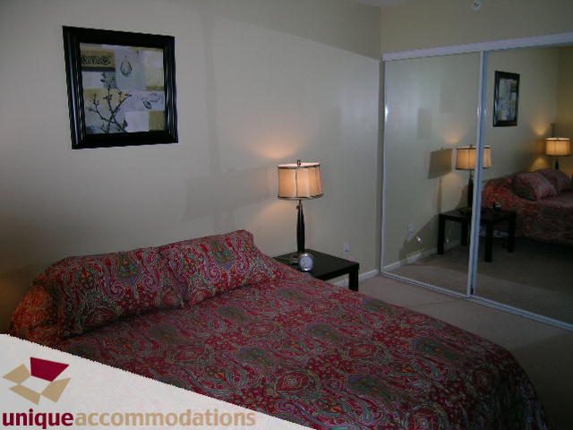 Furnished 2-bedroom condo with patterned bedding and mirrored closet. - 2005 - 1238 Melville, Vancouver Downtown