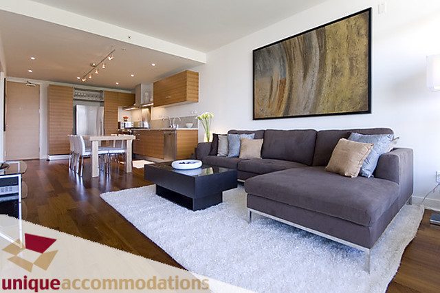 Furnished living room with modern decor, hardwood floors, and a large abstract wall art piece. - 505 - 1808 West 1st Avenue, Vancouver West Side