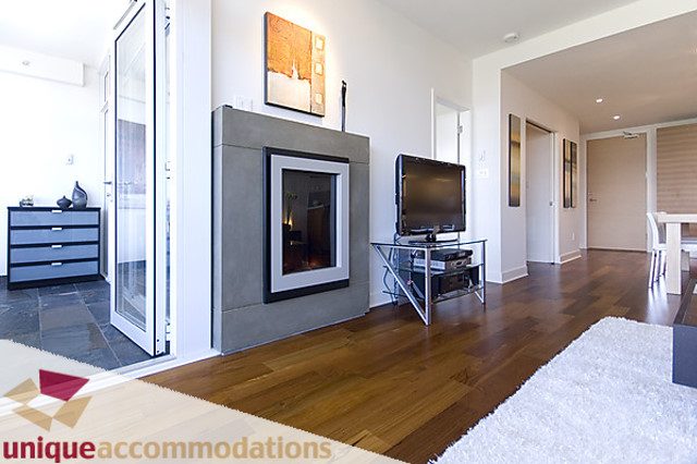 Bright living room with hardwood floors, modern fireplace, and glass coffee table. - 505 - 1808 West 1st Avenue, Vancouver West Side