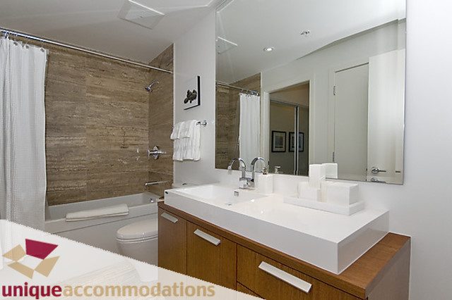 Furnished 1-bedroom + den with modern white countertops and wooden cabinetry. - 505 - 1808 West 1st Avenue, Vancouver West Side
