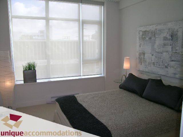 Spacious bedroom with large windows, modern art, and cozy bedding. - 307- 1808 West 1st Avenue, Vancouver West Side