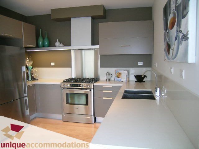 Bright kitchen with modern stainless steel appliances, white countertops, and hardwood floors. - 307- 1808 West 1st Avenue, Vancouver West Side