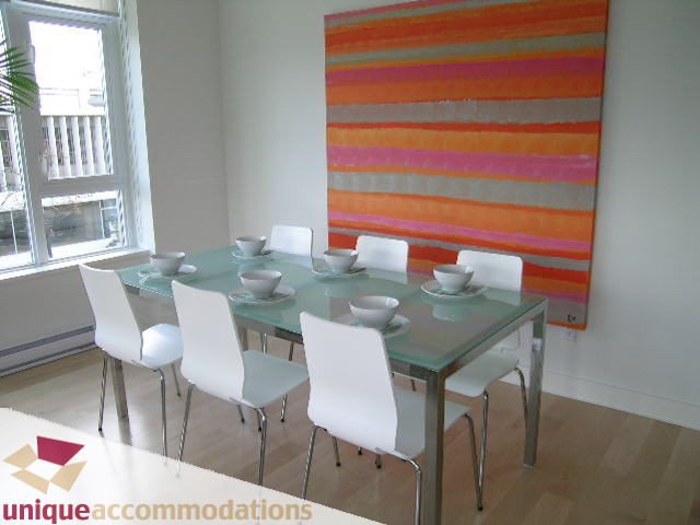 Bright dining area with modern chairs and a colorful abstract painting, hardwood floors. - 307- 1808 West 1st Avenue, Vancouver West Side