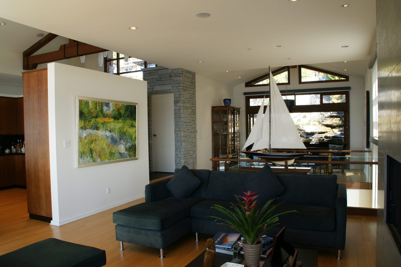 Spacious living room with hardwood floors, modern sectional sofa, and large window view. - 2456 Hudson Court, West Vancouver