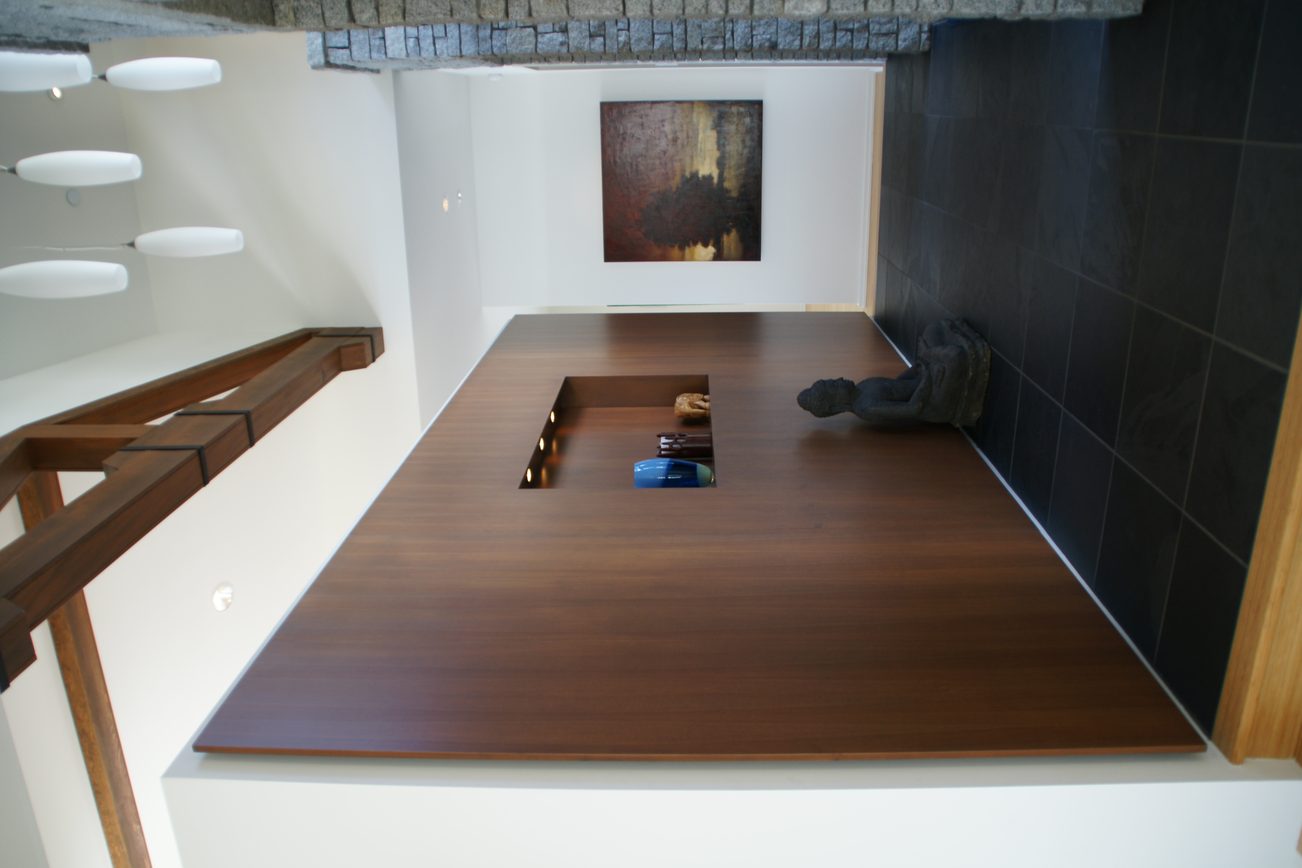 Modern dining area with dark wood table and black tiled wall. - 2456 Hudson Court, West Vancouver