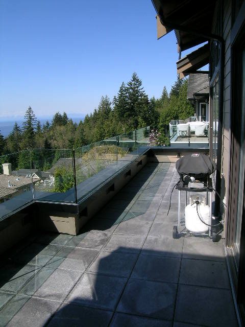 Spacious patio with glass railings, overlooking forest and ocean. - 2456 Hudson Court, West Vancouver