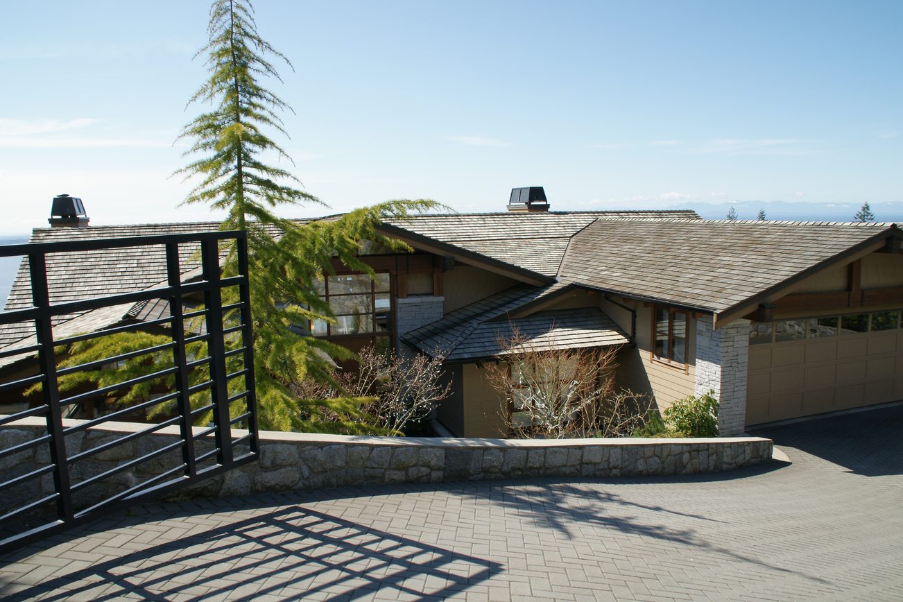 Bright living room with stone walls and a view of the mountains. - 2456 Hudson Court, West Vancouver