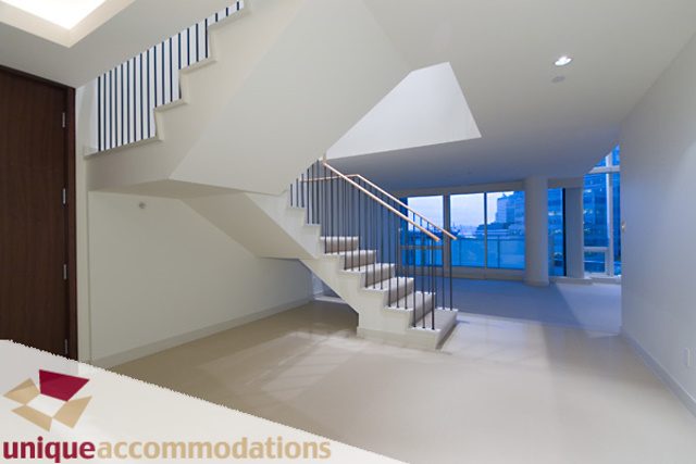 Spacious open-concept living area with modern staircase and large windows offering city views. - 903 - 1139 West Cordova Street, Vancouver Downtown