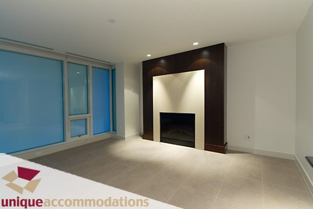 Bright living room with modern decor, large windows, and a dark accent wall. - 903 - 1139 West Cordova Street, Vancouver Downtown