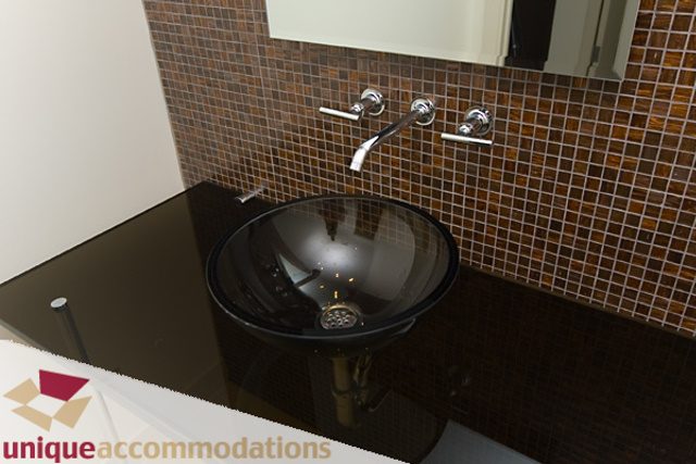 Modern bathroom with black countertop and mosaic wall tiles. - 903 - 1139 West Cordova Street, Vancouver Downtown