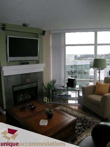 Spacious living room with large windows, city view, and modern furnishings. - 1807 - 198 Aquarius Mews, Vancouver Downtown