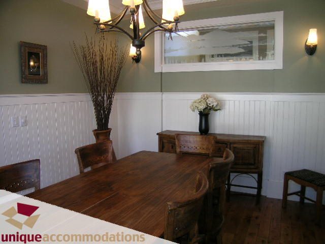 Dining room with wooden table, wainscoting, and chandelier. - 3290 St. Georges Ave, North Vancouver