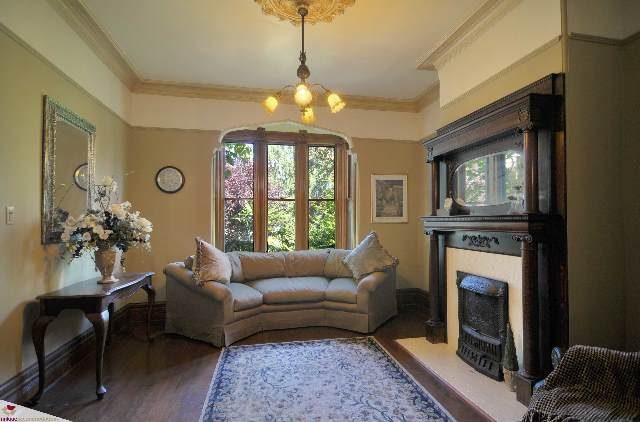 Furnished living room with elegant fireplace, large windows, and floral rug. - 1150 Haro Street, Vancouver Downtown