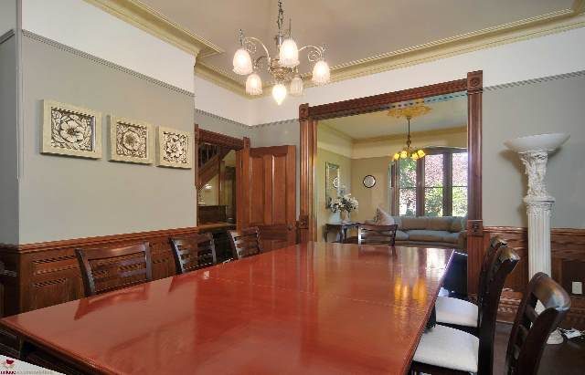 Formal dining room with ornate mirror and chandelier, hardwood floors, and large windows. - 1150 Haro Street, Vancouver Downtown