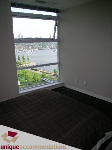Spacious bedroom with large window offering a stunning city view. - 1001- 633 Kinghorne Mews, Vancouver Downtown