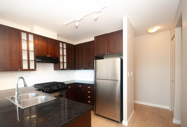 Bright kitchen with granite countertops and stainless steel refrigerator. - 606 - 170 1st Street West, North Vancouver