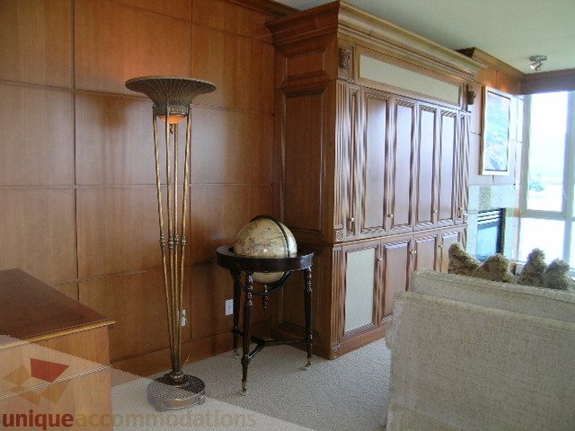 Furnished living room with wooden paneling, globe, and floor lamp. - 802 - 323 Jervis Street, Vancouver Downtown