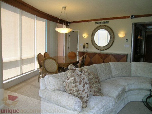 Bright living room with large windows, plush couches, and a round mirror. - 802 - 323 Jervis Street, Vancouver Downtown
