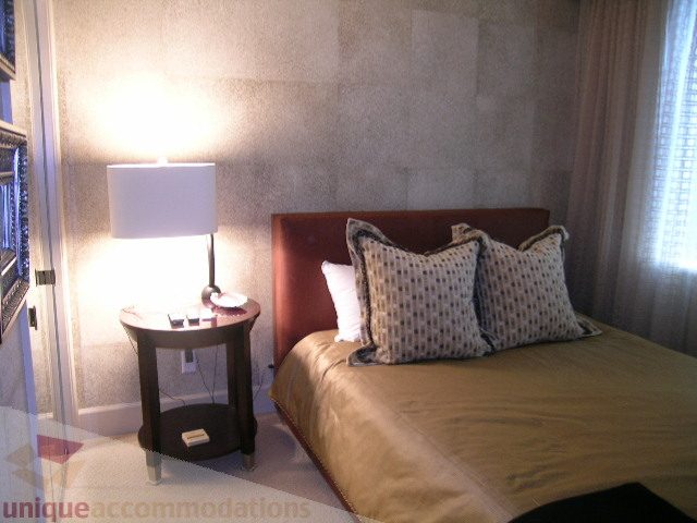 Furnished bedroom with cozy bedding and a side table with a lamp. - 802 - 323 Jervis Street, Vancouver Downtown