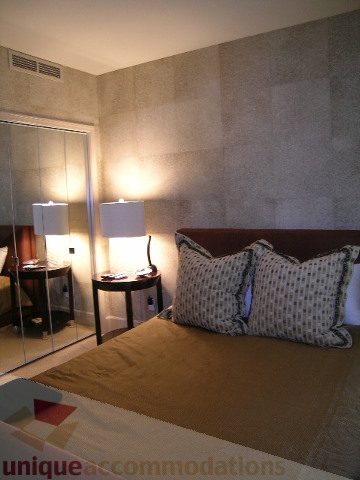 Spacious bedroom with two beds, patterned pillows, and a large mirror. - 802 - 323 Jervis Street, Vancouver Downtown