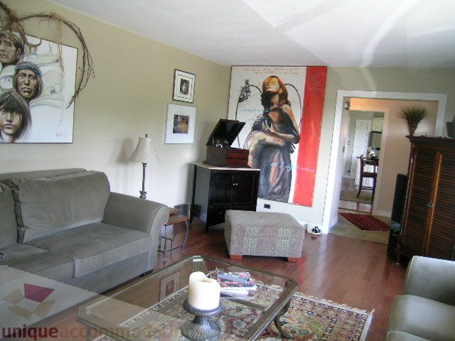 Living room with hardwood floors, modern decor, and large artwork on the walls. - 4104 Sunnycrest drive, North Vancouver