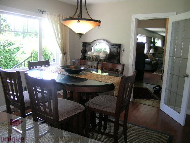 Furnished dining room with hardwood floors, large windows, and a view of the garden. - 4104 Sunnycrest drive, North Vancouver