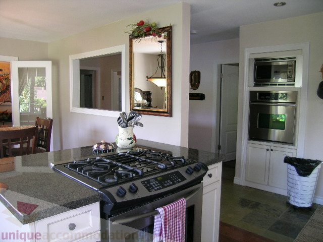 Bright kitchen with granite countertops, stainless steel appliances, and hardwood floors. - 4104 Sunnycrest drive, North Vancouver