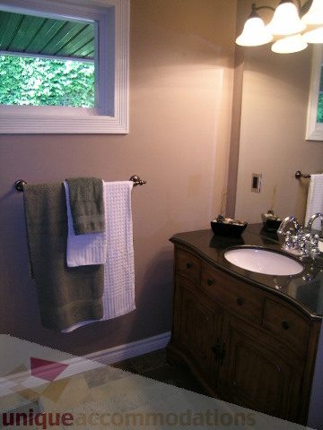 Furnished bathroom with wooden vanity, white countertop, and towel rack. - 4104 Sunnycrest drive, North Vancouver