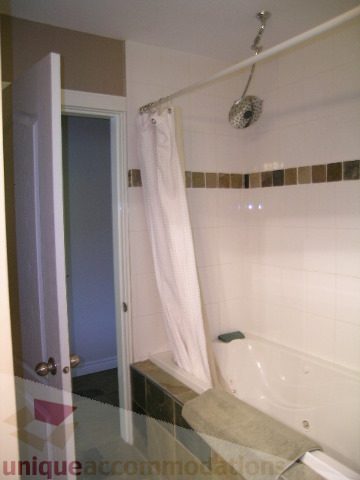 Bathroom with white fixtures and tiled walls. - 4104 Sunnycrest drive, North Vancouver