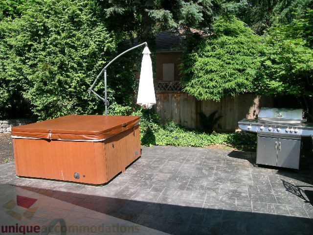 Furnished patio with hot tub, umbrella, and stone flooring. - 4104 Sunnycrest drive, North Vancouver