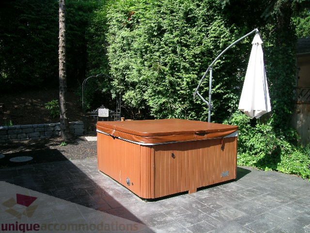 Outdoor hot tub with wooden deck and lush greenery. - 4104 Sunnycrest drive, North Vancouver