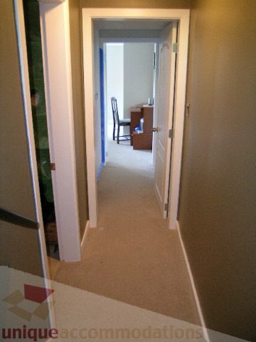 Furnished hallway leading to a room with a desk and chair, carpeted floors. - 4104 Sunnycrest drive, North Vancouver