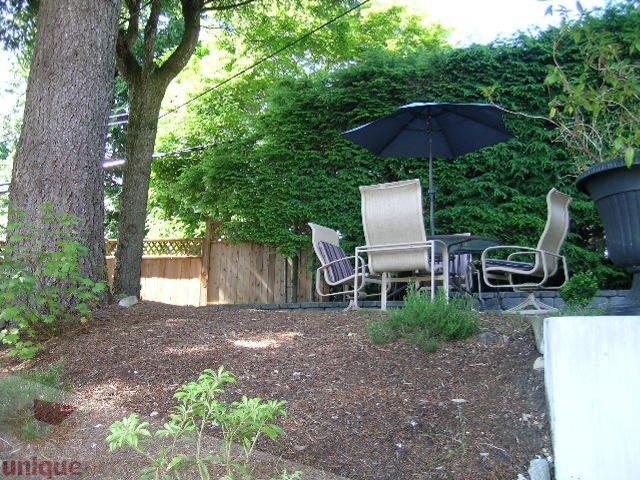 Furnished patio with lounge chairs and umbrella, surrounded by greenery. - 4104 Sunnycrest drive, North Vancouver