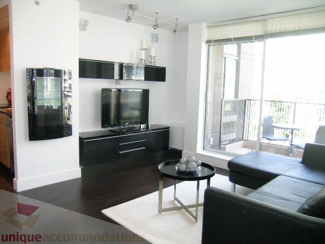Bright living room with hardwood floors, modern furniture, and a city view. - 705 - 1055 Homer Street, Vancouver Downtown